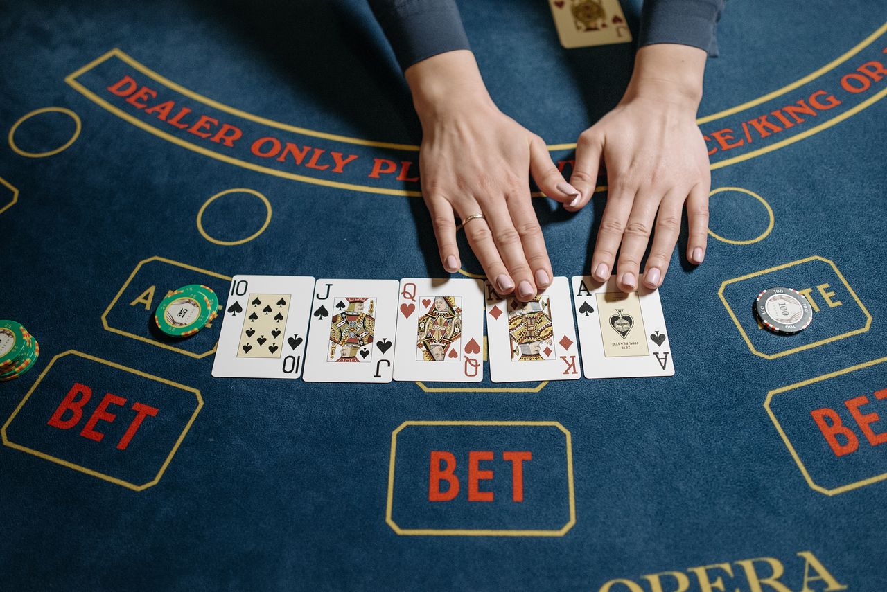 Cards laid in a row on a navy casino table with betting markers