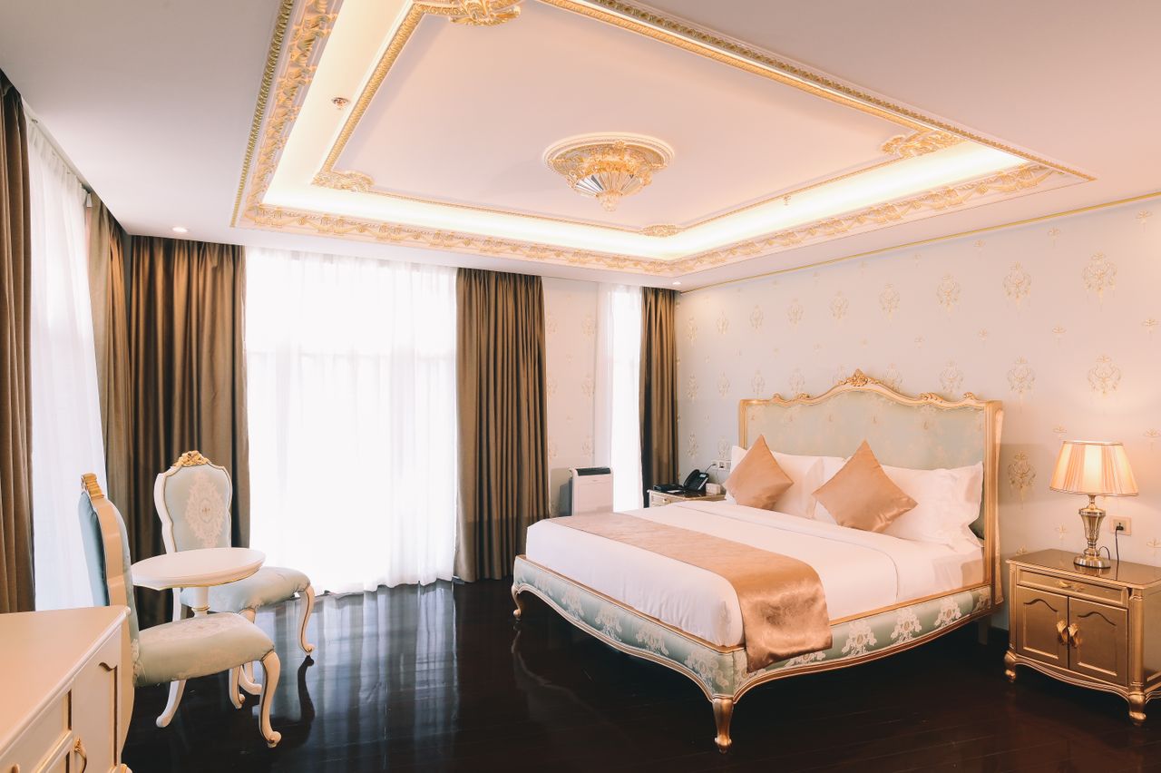 Light blue and gold suite with tray ceiling and draped windows