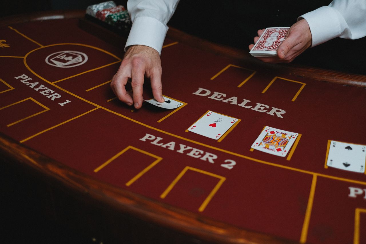 Dealer revealing cards on a red felt gaming table