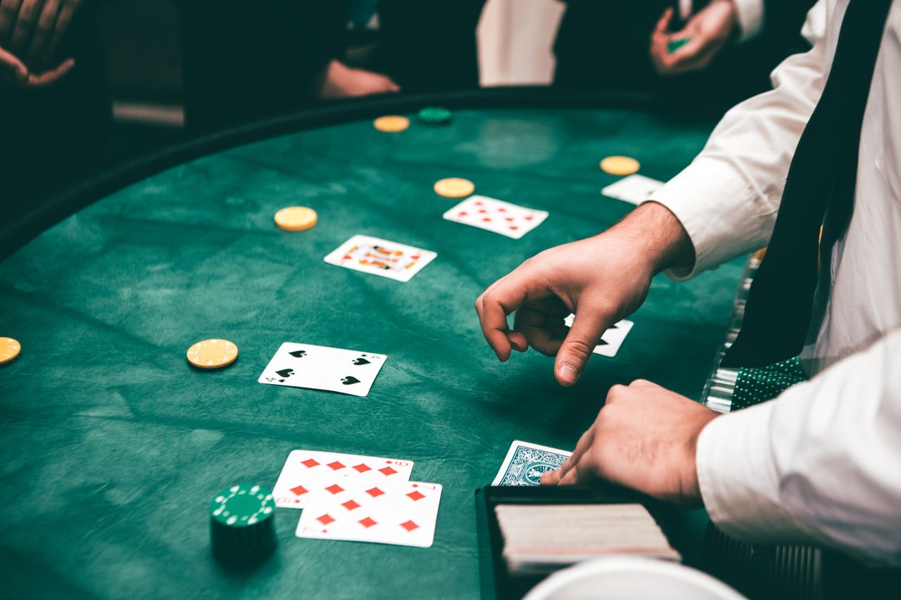 Dealer managing cards and chips on a green gaming table